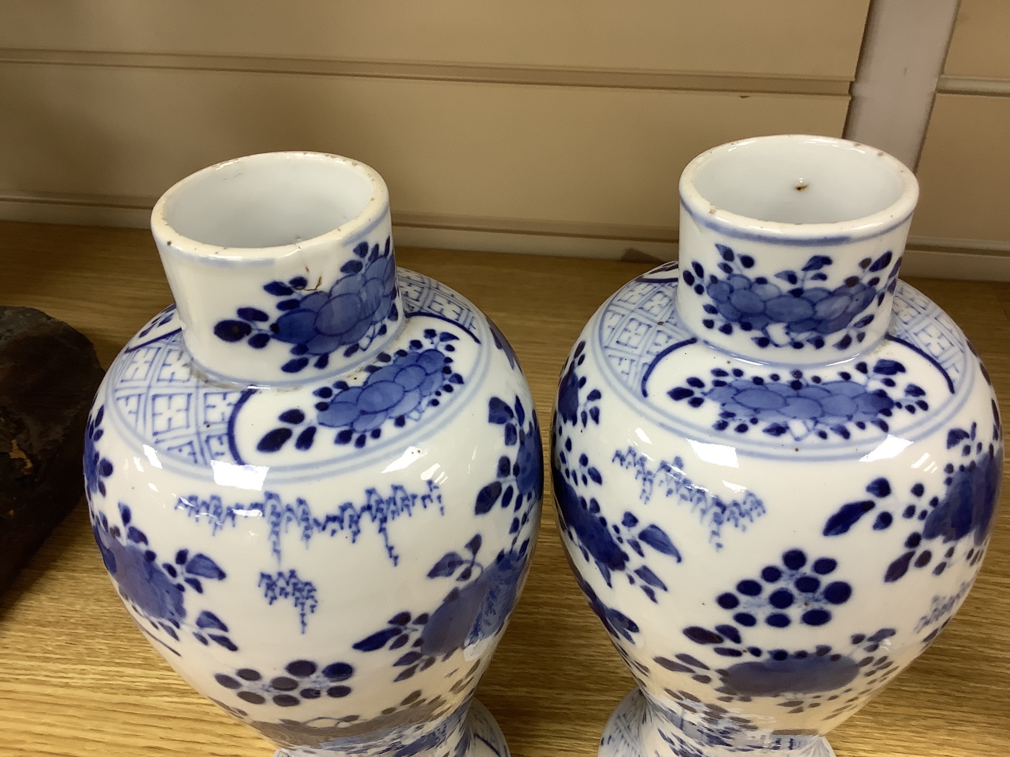 A pair of lidded Chinese blue and white vases, c.1900, Kangxi marks, 23cm high, together with two small Japanese vases, and a cup and saucer (6)